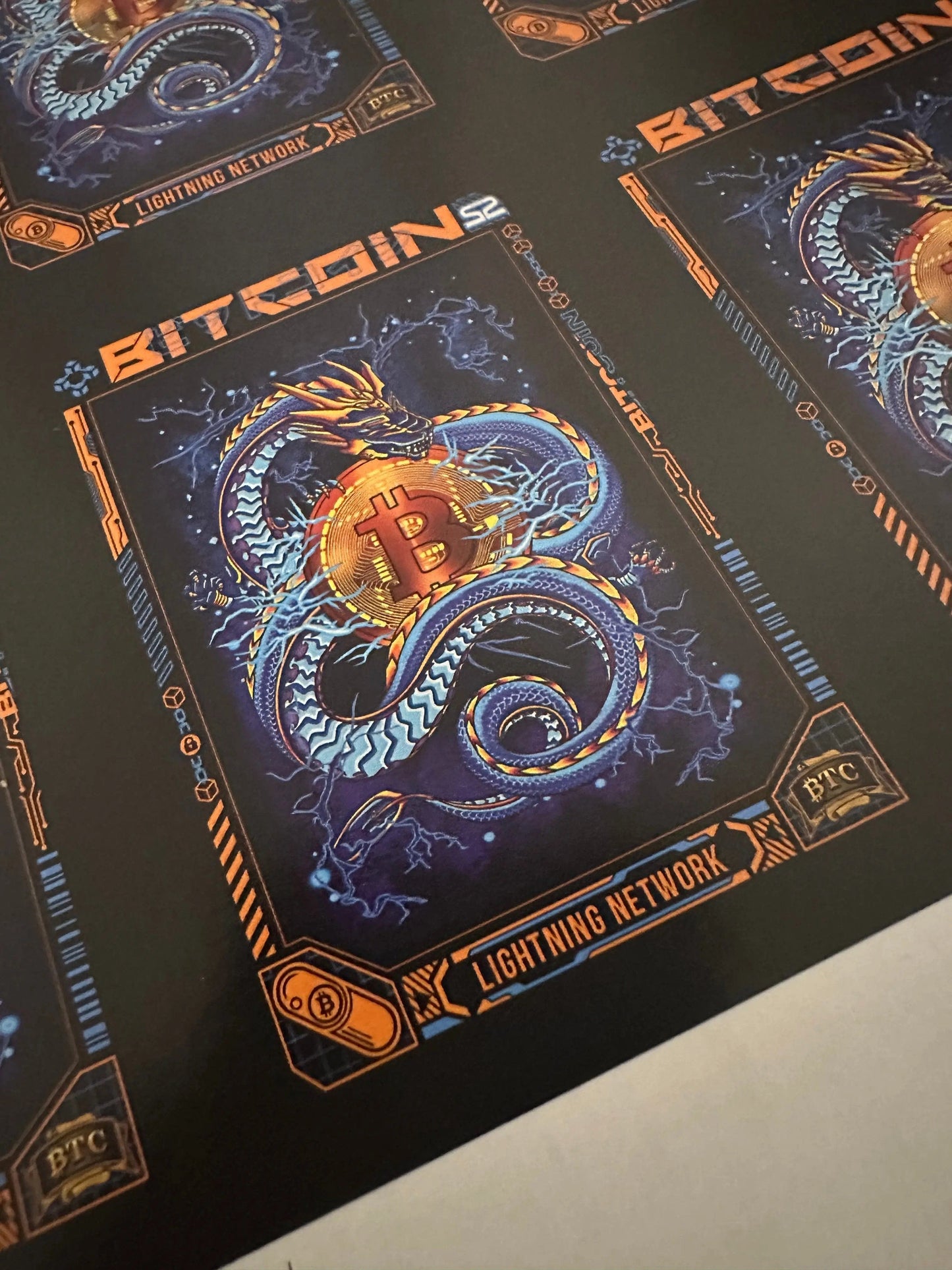 Macro close-up angled view of a single 'Lightning Network' card on the uncut press sheet, detailing the blue dragon and Bitcoin logo artwork.