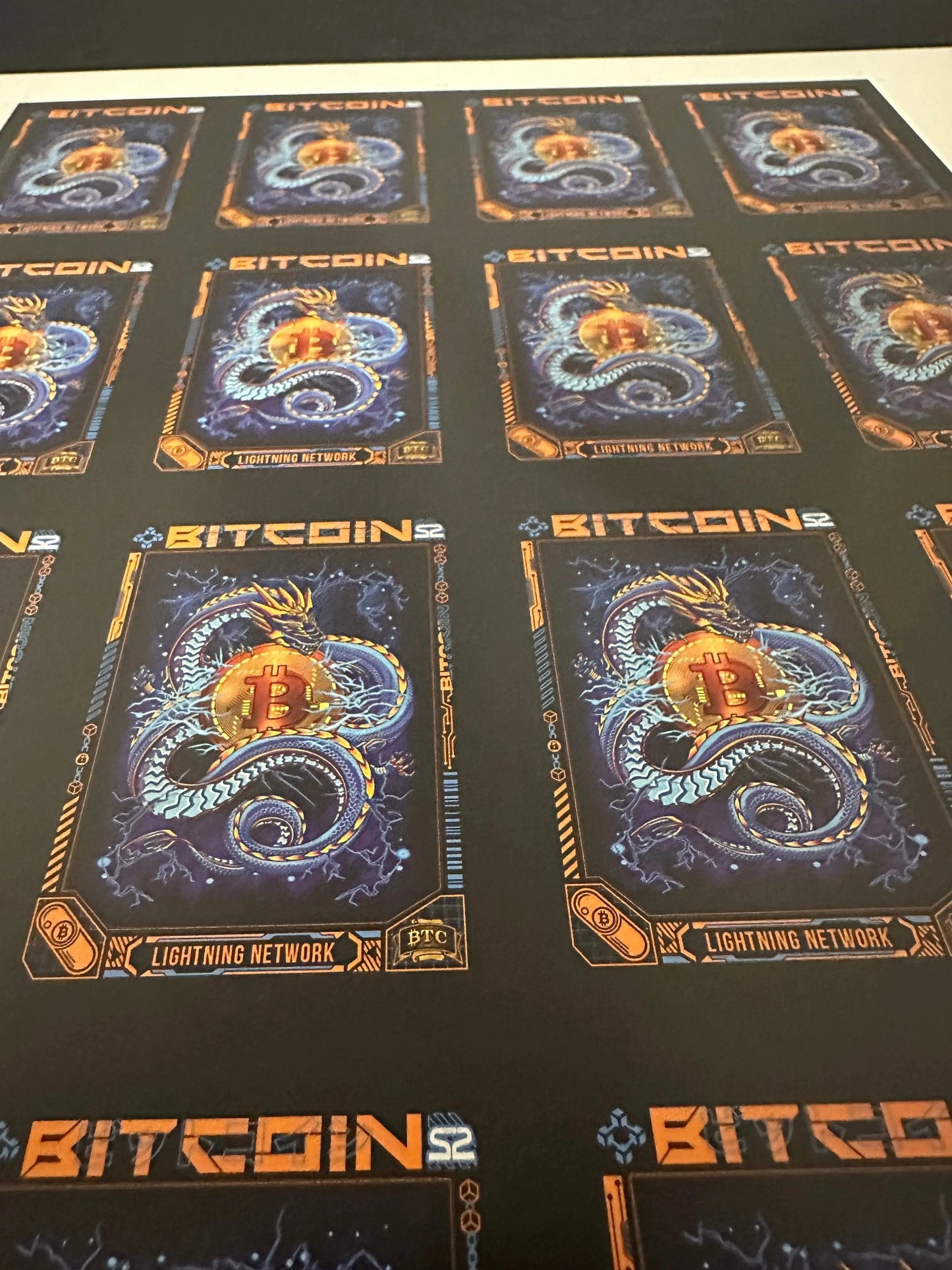 Low-angle perspective view of an uncut production press sheet for Bitcoin Trading Cards focusing on the rows of 'Lightning Network' blue dragon artwork.