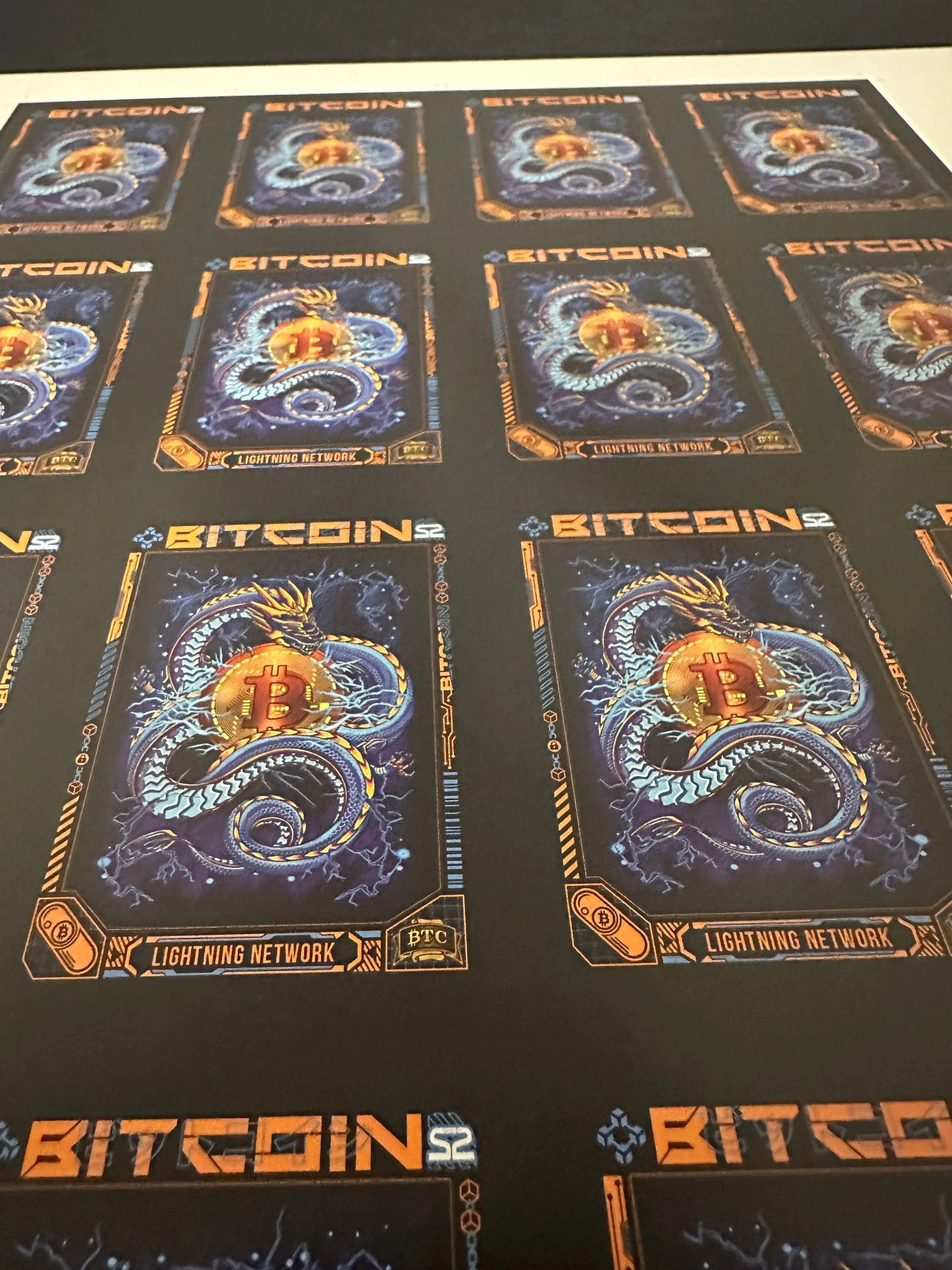 Low-angle perspective view of an uncut production press sheet for Bitcoin Trading Cards focusing on the rows of 'Lightning Network' blue dragon artwork.