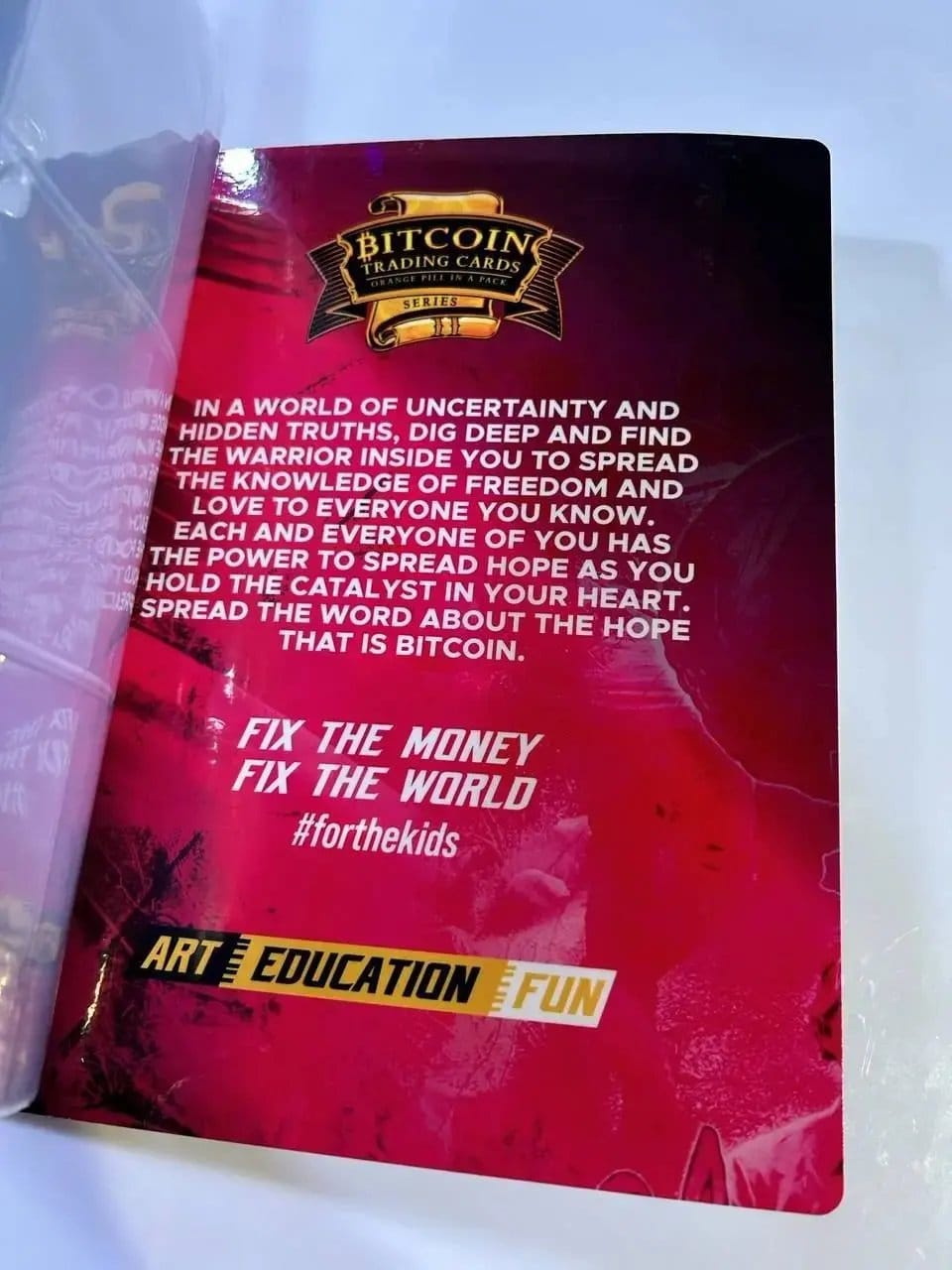 Interior page of the Bitcoin Trading Cards Series 2 binder featuring the inspirational mission statement text 'Fix the Money, Fix the World' and '#forthekids'.