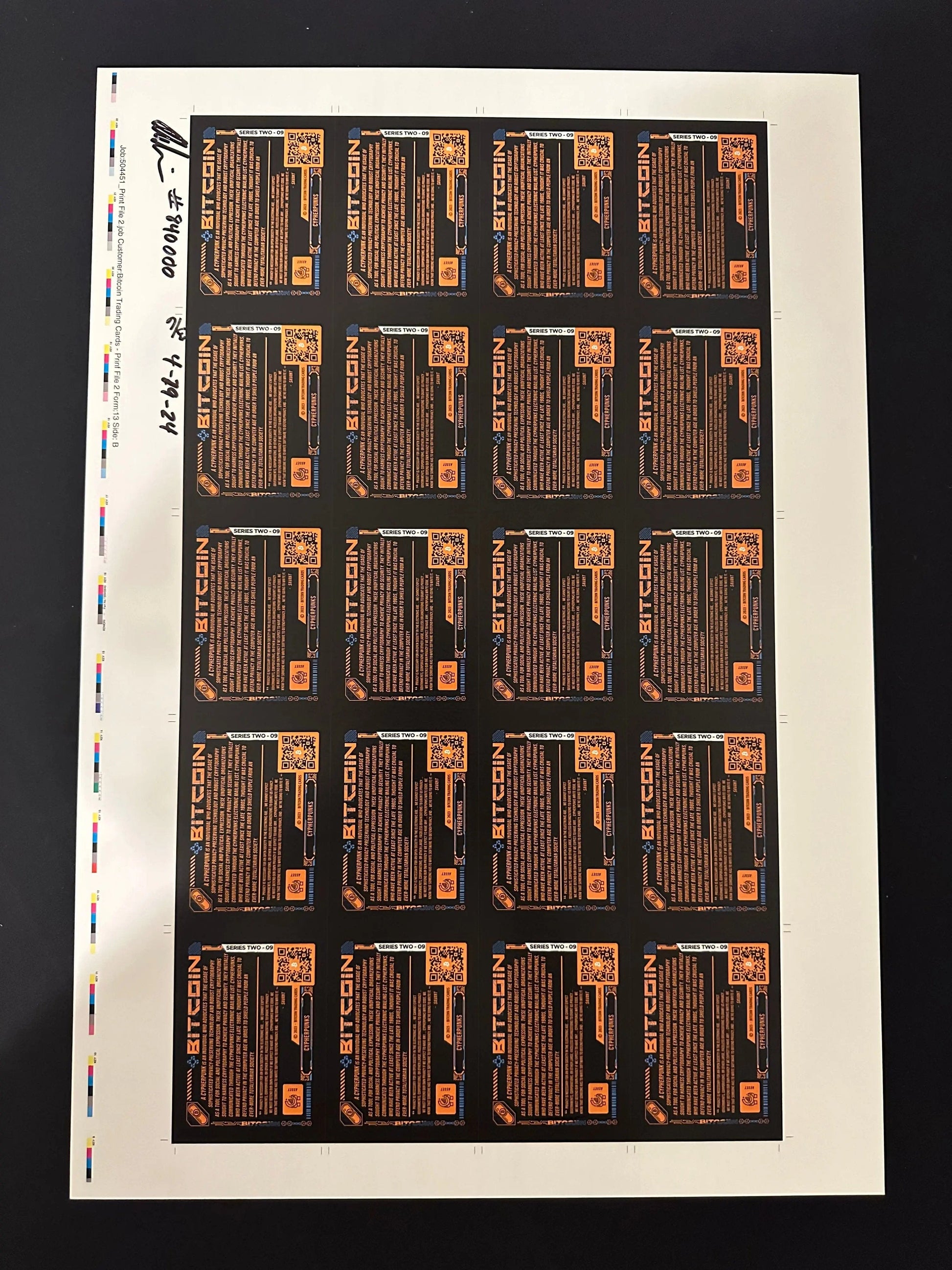 Back of an uncut production press sheet for Bitcoin Trading Cards displaying the text side of 'Cypherpunks' cards with printer color bars and handwritten approval signatures.